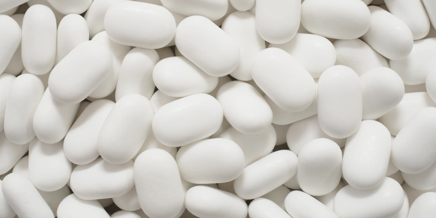 A close-up pile of plain white tablets